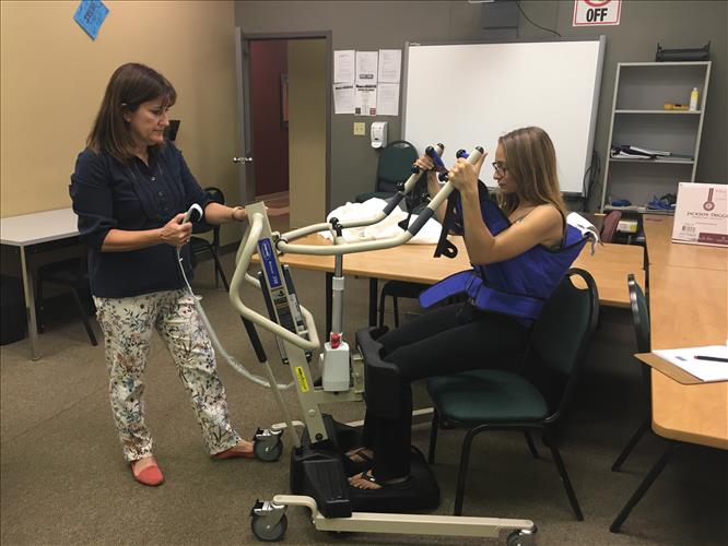 A student and instructor work to demonstrate safe use of a mobility assistance device