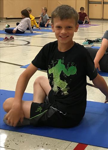 A student twists on a yoga mat