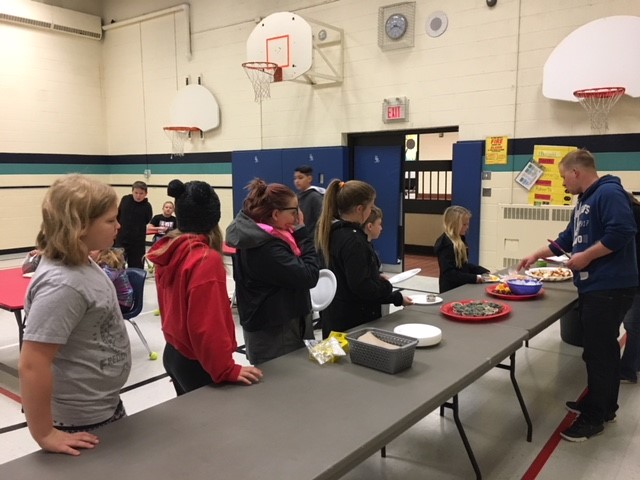 Students are served a hot breakfast by teachers