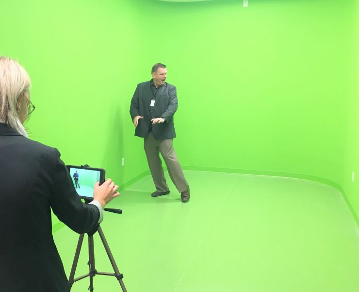 A man dances in front of a green screen