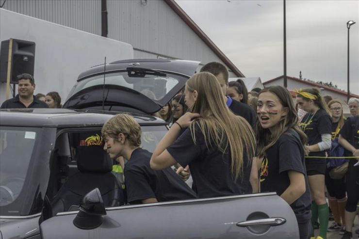A group of Grade 9 students peers into a small car