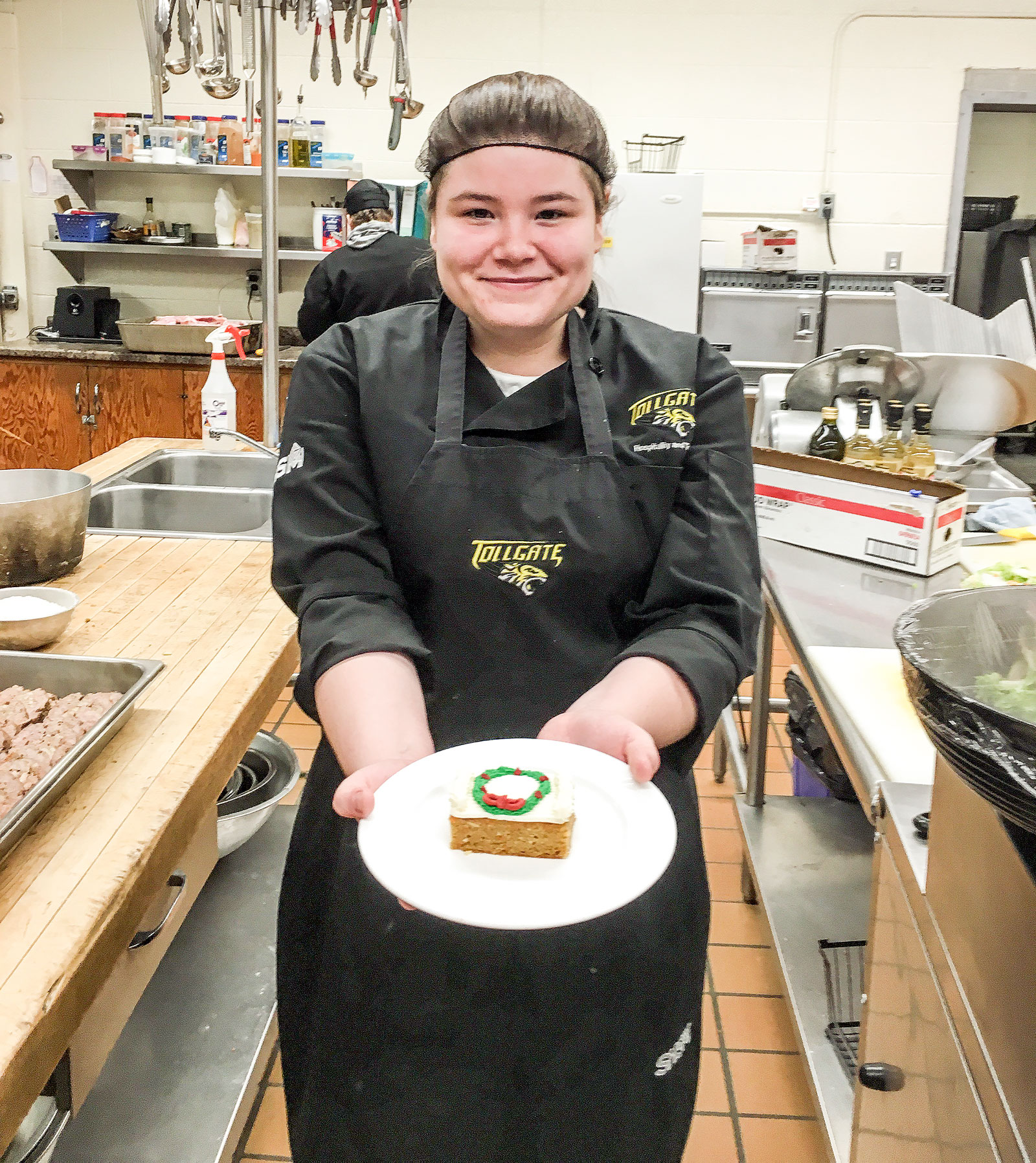 Student Amanda shows off a freshly frosted piece of carrot cake.