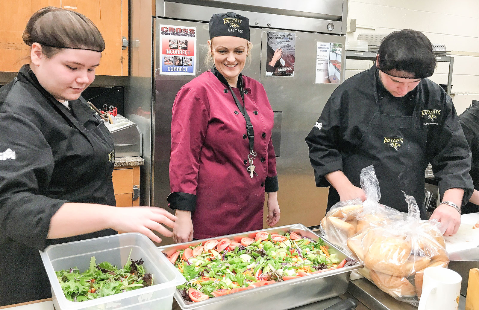 Food Technician Melanie Cattle works with students to prepare salads.