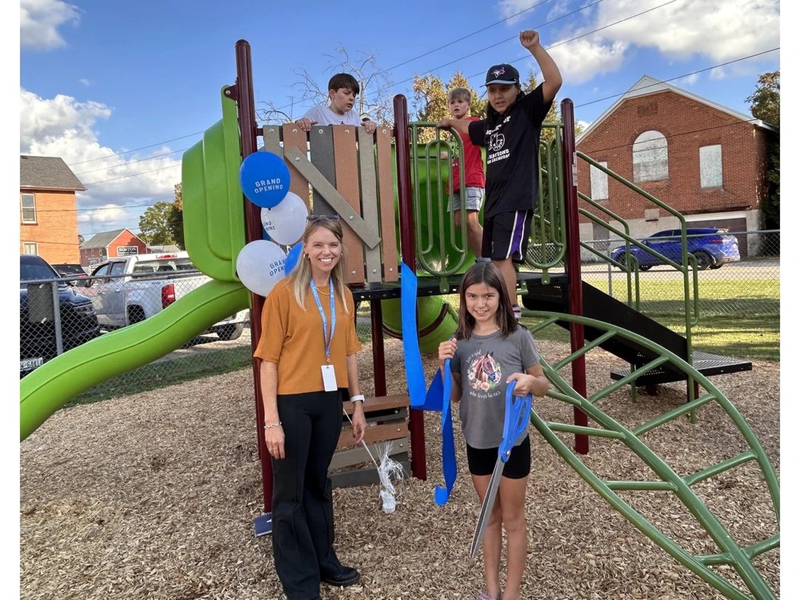students and principal standing by playground