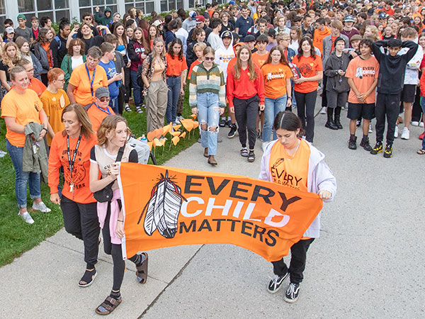 Students hold an Every Child Matters banner