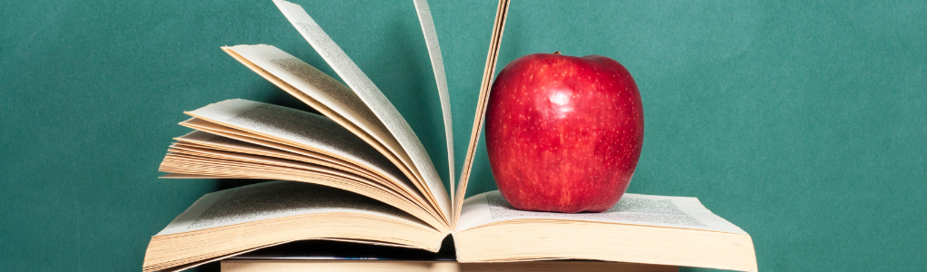 Apple sitting on open book