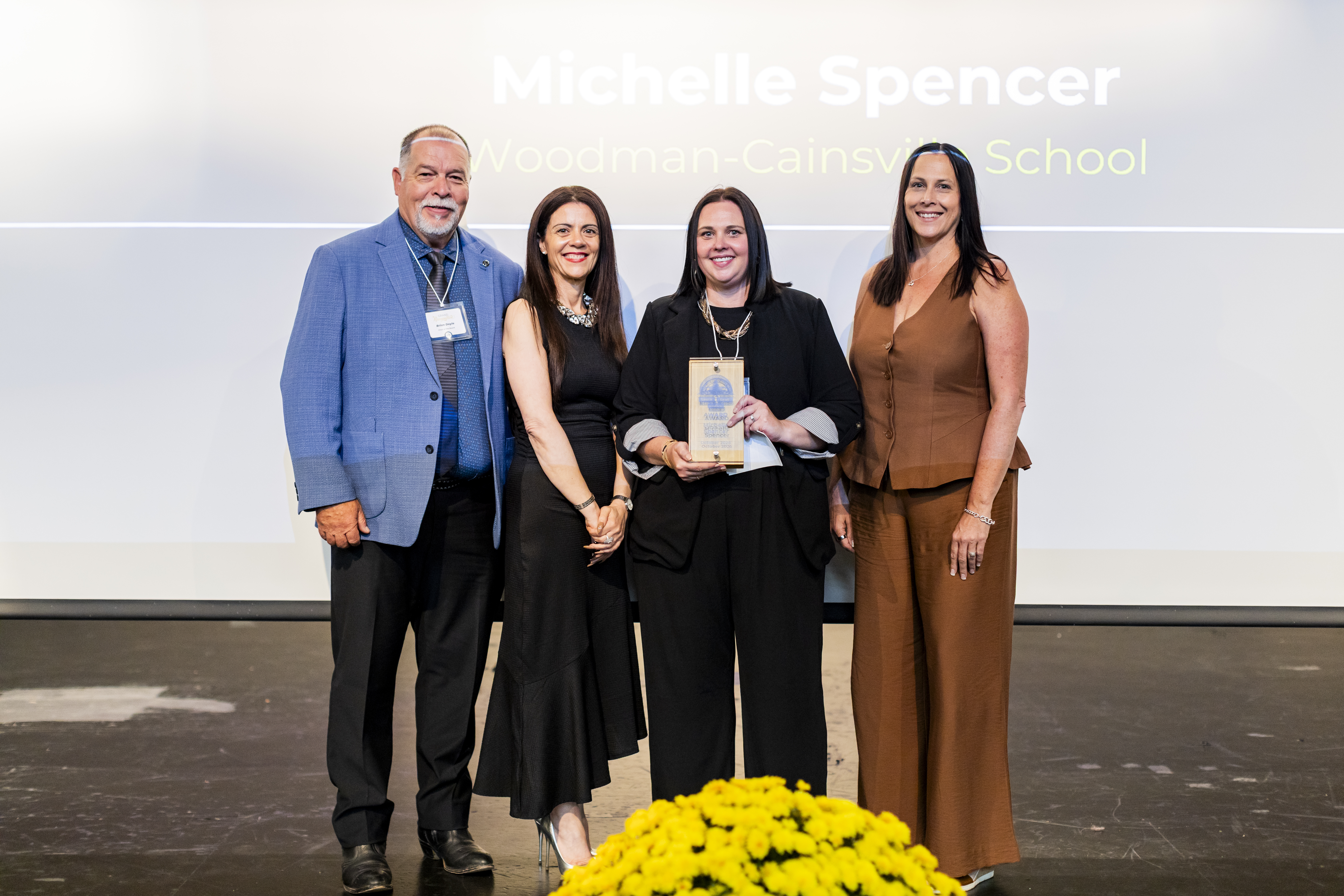 Brian Doyle, JoAnna Roberto, Michelle Spencer, Julie White standing on stage for LLI recognition.