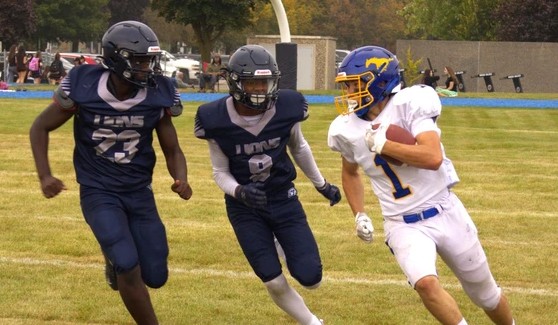 Mitch Potter outruns Assumption College defenders Xavier Gyan and Josh Guimaraes during an AABHN senior football game