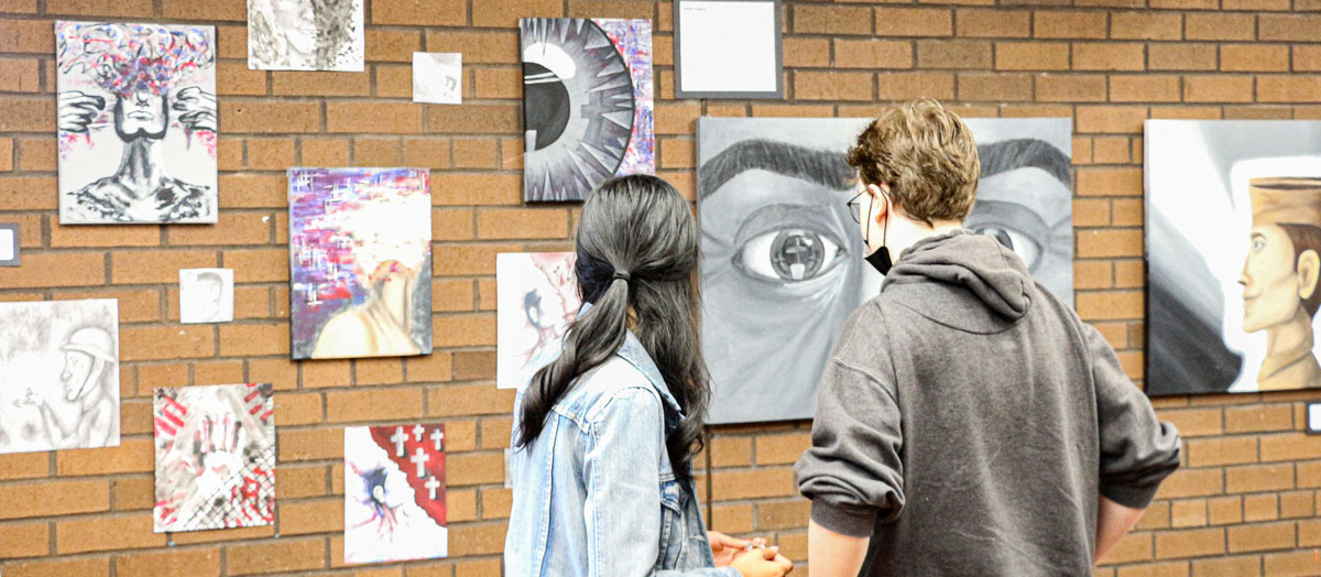 a girl and a boy watching art