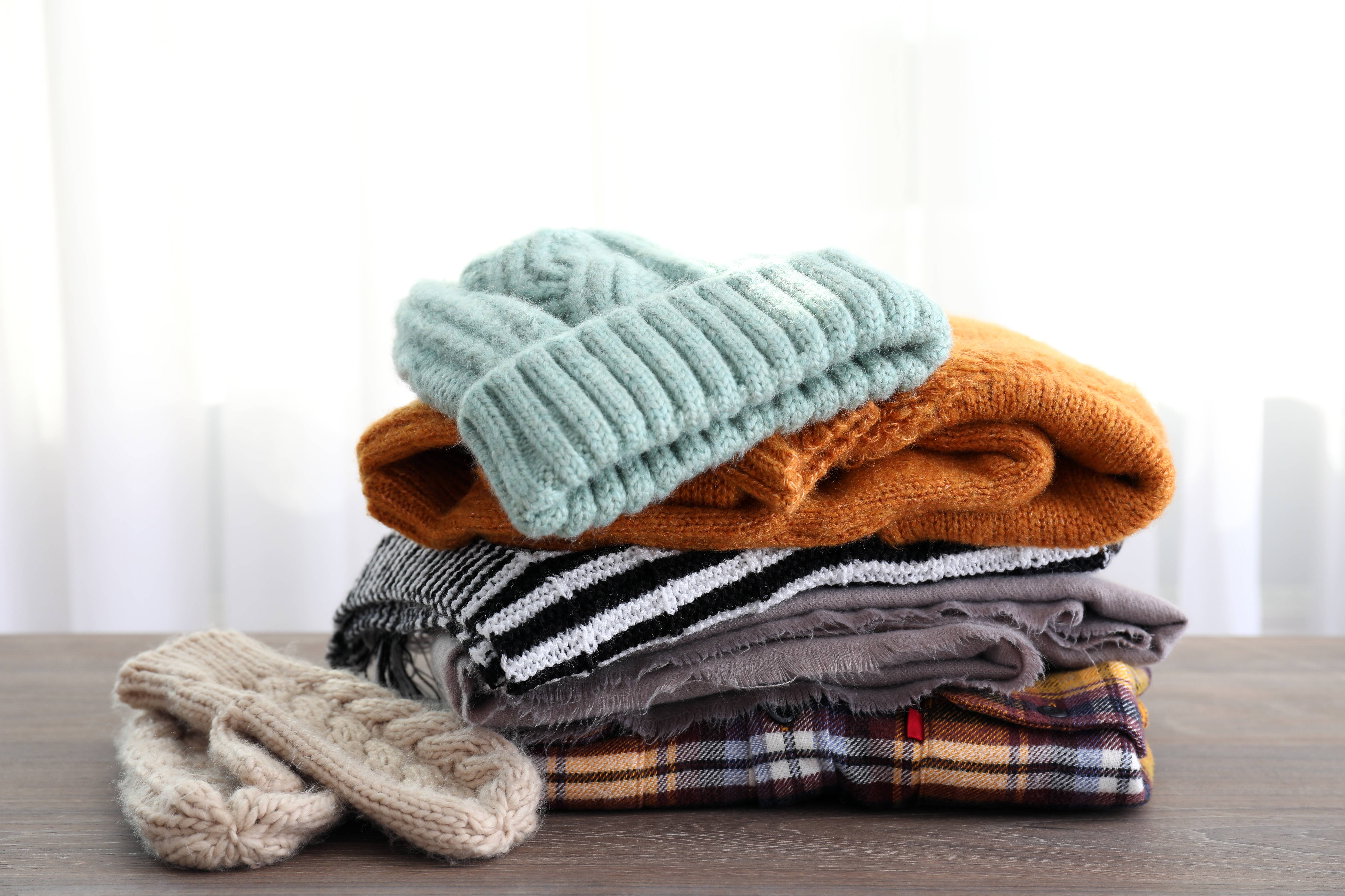 Pile of winter clothes on wooden table