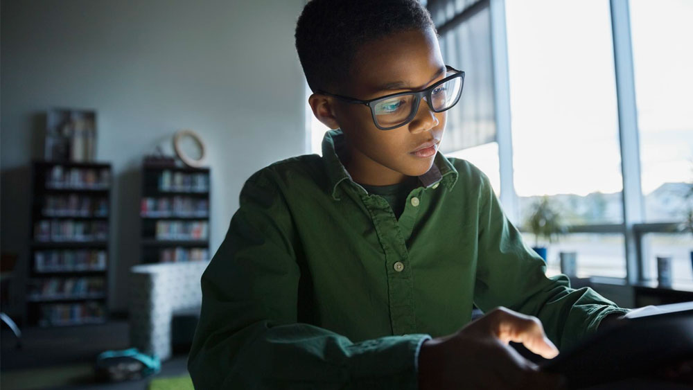 Young student looking at computer in classroom